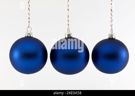 Drei blaue Weihnachtskugeln auf weißem Hintergrund fotografiert Stockfoto