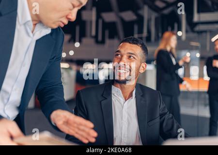 Zwei multiethnische Kollegen arbeiten gemeinsam an einem Projekt in einem modernen Büro Stockfoto