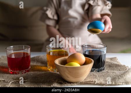 Nettes Mädchen zu Hause in der Küche färbt Eier für Ostern Stockfoto