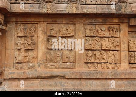 Thanjavur, Tamil Nadu, Indien - 31. Oktober 2022: Eine Steinmauer mit einer Schnitzerei hinduistischer Gottheiten im alten Tempel von Tanjore. Stockfoto
