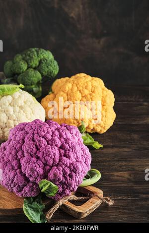 Farbenfroher Blumenkohl. Verschiedene Arten von Blumenkohl auf alten hölzernen Hintergrund. Violette, gelbe, weiße und grüne Farbkabbage. Brokkoli und Romanesco. Ag Stockfoto