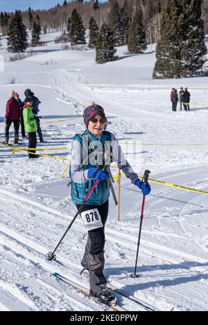 Eine ältere Frau auf Langlaufskiern tritt im Chama, Chile Ski Classic in den San Juan Mountains in der Nähe von Chama, New Mexico, an. Stockfoto