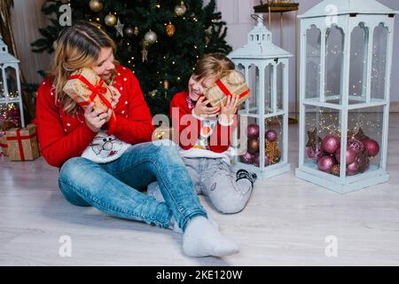 Familie heiligabend Mutter und Tochter öffnen Geschenke Stockfoto