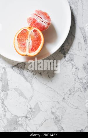 Minimal Red Navel Orange Flat Lay on White Marble Stockfoto