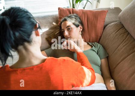 Mutter überprüft die Temperatur der Tochter mit einem elektronischen Thermometer Stockfoto