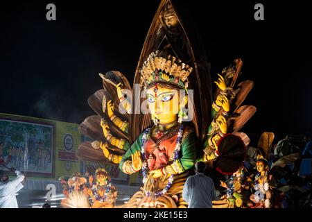 Rote Straße in Kalkutta Westbengalen, Indien am 8.. Oktober 2022 - Stammesleute genießen die Prozession des Durga Puja Karnevals Stockfoto