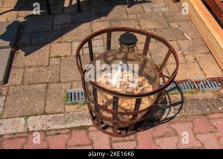 Bojnice, Slowakei - 06.11.2022: Große Weinflasche mit gebrauchten Korken für Wein in metallischem Rahmen. Dekoration in einer Bierbar. Stockfoto
