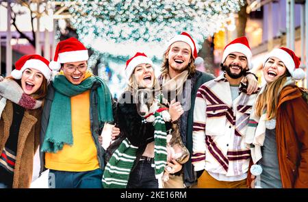 Echte Freunde Gruppe Spaß zusammen mit niedlichen Hund auf Weihnachten Winter Advent - Weihnachten Lifestyle-Konzept mit trendigen jungen Menschen tragen roten sant Stockfoto