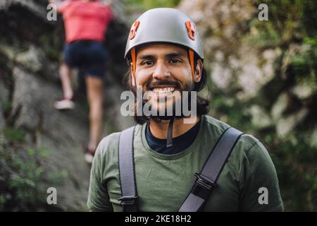 Porträt eines lächelnden Mannes mit Sporthelm beim Klettern Stockfoto