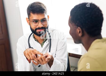 Indischer Arzt Therapeut im weißen Mantel Beratung Patienten in modernen Klinik Krankenhaus unterstützen Stockfoto