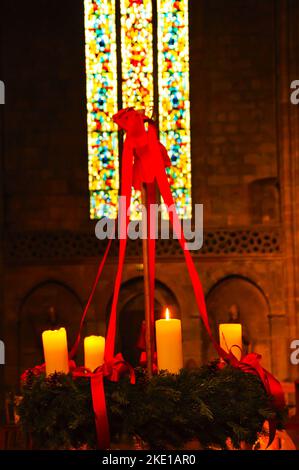 Adventskranz mit 4 Kerzen in der Kirche. Selektiver Fokus auf die brennende Kerze. Stockfoto