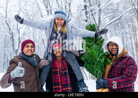 Outdoor Lifestyle-Porträt von vier besten Freunden, die den Baum nach Hause tragen Stockfoto