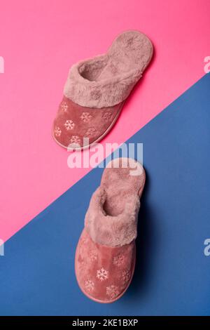 Rosa warme Damenschuhe auf einem rosa und blauen Hintergrund Stockfoto