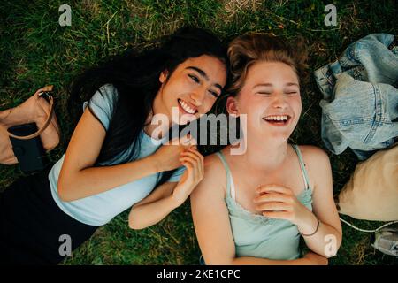 Hochwinkel-Ansicht fröhlich von weiblichen Freunden auf Gras liegen Stockfoto