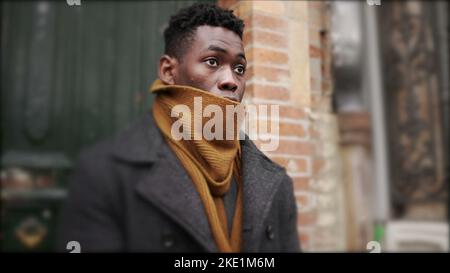 Afrikanischer Mann verlässt morgens während der Wintersaison das Haus, elegante Person tritt heraus Stockfoto