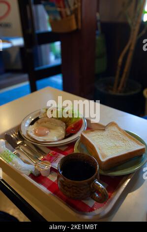 Ein japanisches Frühstück im „westlichen“ Stil, das in einem Café serviert wird, inklusive Ei, Salat, Toast und Kaffee. Stockfoto