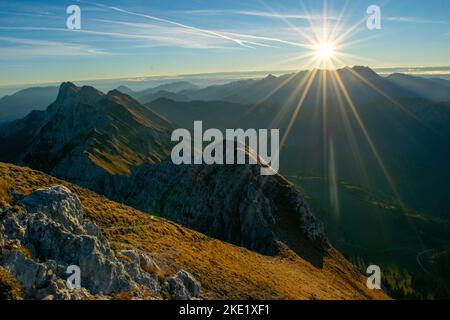 Am frühen Morgen mit herrlichem Sonnenlicht mit goldenem Gras und herrlichem Bergrücken. Stockfoto