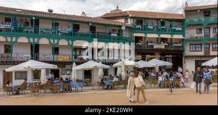 Die Gäste sitzen an Tischen auf Balkonen und am Boden rund um den zentralen platz (der auch als Stierkampfarena fungiert) der spanischen Stadt Chinchon in der Nähe von Madrid, Spai Stockfoto