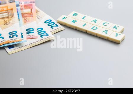 Schwarzer freitagstext und Euro-Geld auf grauem Hintergrund. Stockfoto