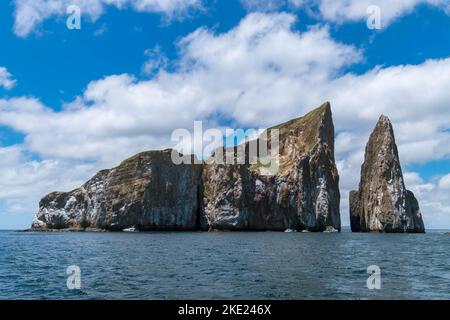 Eine Nahaufnahme der Felseninsel Kicker von einem Boot aus nach einem Taucherlebnis. Der Himmel ist an einem sonnigen Tag auf der Insel San Cristobal auf Galapagos GA bewölkt Stockfoto