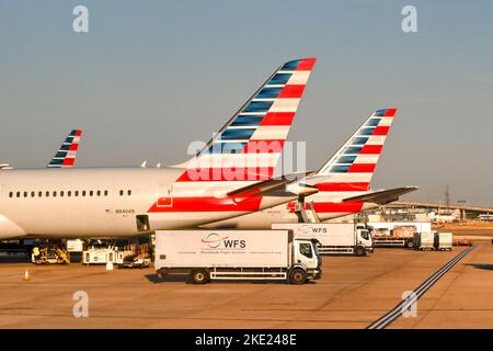 London, England - August 2022: Vor den Heckflossen amerikanischer Ailrines-Flugzeuge parkte Laderaumlastwagen Stockfoto