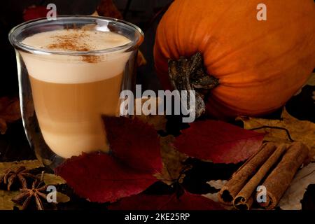 Hitzebeständiger Glasbecher mit Cappuccino oder Latte und reifem Kürbis Stockfoto