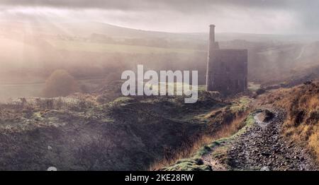 Der frühe Morgennebel schmilzt langsam ab, während die Sonne durch die tief liegende Wolke im Tal nahe Mary Tavy und den Fußweg hinunter nach W bricht Stockfoto