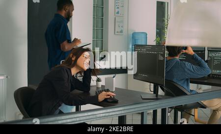 Systemingenieur, der sich bei der Programmierung der Idee sicher fühlt und den Quellcode auf der neuen Serverschnittstelle eingibt. Zufrieden asiatischen Coder Entwicklung Software-Programm und Web-Datenbank auf Computer. Stockfoto