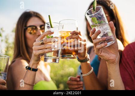 Fröhliche Gruppe von tausendjährigen Freunden toasten alkoholische Cocktails im Sommer - Menschen sammeln Jubel und trinken alkoholische Getränke Lifestyle Co Stockfoto