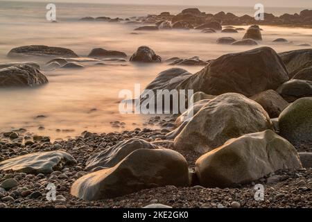 Felsige Küste und Surfen bei Sonnenuntergang, Gros Morne National Park, Neufundland und Labrador NL, Kanada Stockfoto