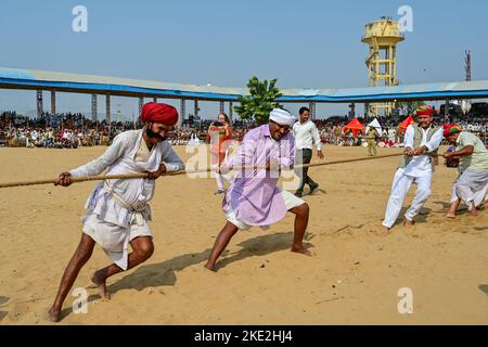 Pushkar, Rajasthan, Indien. 4.. November 2022. Blick von der jährlichen Pushkar Fair, die im November nach Diwali stattfindet. Ursprünglich ein Viehmarkt, jetzt ist es ein farbenfroher Jahrmarkt. Die Pushkar-Messe ist eine der größten Kamel-, Pferde- und Rindermessen Indiens. Neben dem Handel mit Vieh, ist es eine entscheidende Wallfahrtszeit für Hindus zum Pushkar See. Pushkar Messe hat sich auch zu einer bedeutenden Touristenattraktion für inländische und internationale Reisende, angesichts der mehr fantastische Saison, und die Fülle von bunten kulturellen Themen. Kulturelle Veranstaltungen und Wettbewerbe umfassen Tänze, Tauziehen zwischen Frauen Stockfoto