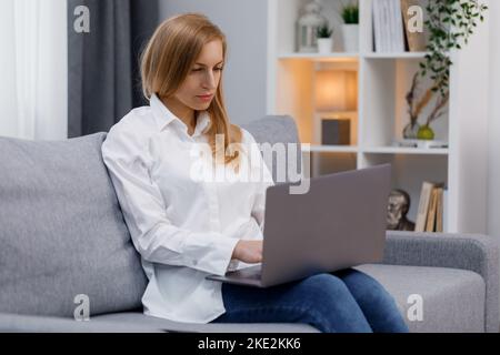 Fokussierte Frau, die am Laptop arbeitet Stockfoto