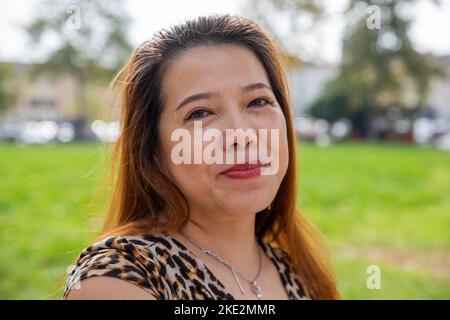 Schöne chinesin, die während einer Schussstunde in einem Park friedlich aufschaut. Stockfoto