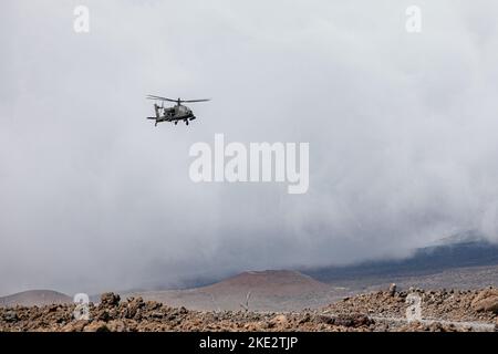 Ein Hubschrauber der U.S. Army Boeing AH-64 Apache mit der 2. Squadron, dem 6. Cavalry Regiment, der 25. Combat Aviation Brigade, der 25. Infantry Division, fliegt während des Trainings im Pohakuloa Training Area, Hawaii, 3. November 2022, über einen Tankpunkt. Joint Pacific Multinic Readiness Center 23-01 ist eine realistische Trainingsrotation, die es uns ermöglicht, strategische Bewegungen zu üben und in einzigartigen Umgebungen und Bedingungen zu trainieren, wo sie im Falle einer Krise oder eines Konflikts am wahrscheinlichsten eingesetzt werden. (USA Armeefoto von Sgt. Rachel Christensen/28. Public Affairs Detachment) Stockfoto