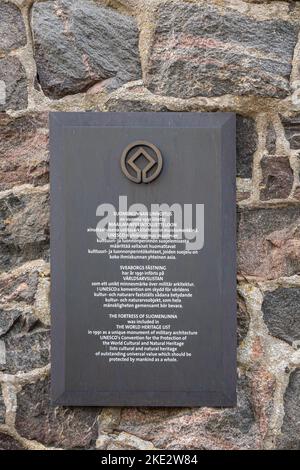 Helsinki, Finnland - 19. Juli 2022: Festung Suomenlinna. Nahaufnahme der Plakette, die in weißen Buchstaben auf grauem Hintergrund erklärt, was die Festung al ist Stockfoto