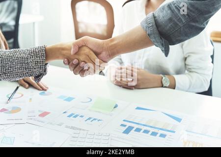 Unternehmensfusion, asiatische Geschäftsleute schütteln die Hände im Konferenzraum und zeigen ihre Zusammenarbeit, um ihre Marketing-Bemühungen zu stärken Stockfoto