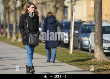 Frau, die im Winter auf dem Platz des Königs Tomislav (Trg Kralja Tomislava) spazierend ist. Zagreb, Kroatien. Stockfoto