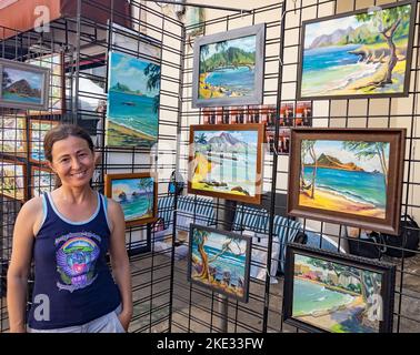 Honolulu, Hawaii, 8. Oktober 2022 - Chinatown Street Art Show - Frau zeigt ihre Gemälde zum Verkauf. Stockfoto