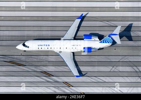 Luftfahrzeug des Typs United Express Mitsubishi CRJ-200 über der Pistenschwelle. FLUGZEUG CRJ200/CRJ-200ER. Flugzeug N487CA, betrieben von SkyWest Airlines. Stockfoto