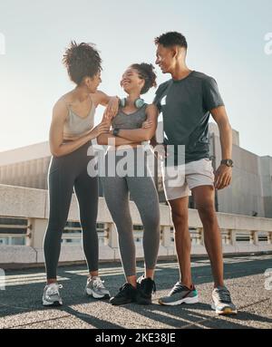 City Running Freunde, die Gruppe lächelt und lacht zusammen auf der Straße nach dem Lauf in der Stadt für Outdoor-Sommer-Workout, Fitness-Training und Training für Marathon Stockfoto