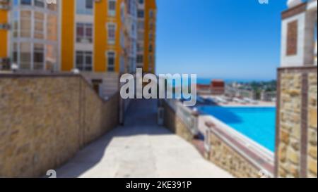 Abstrakter, unscharfer Meerblick mit klarem, unscharfem Himmel, Blick von der Terrasse des Luxushotels in den oberen Stockwerken. Verschwommener Hintergrund von schönen Schwimmen im Freien Stockfoto