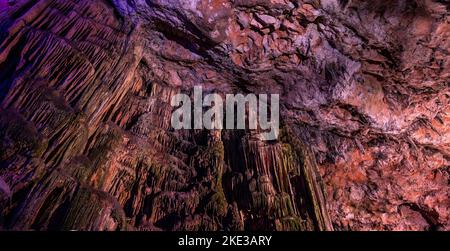 St. Michael's Cave mit bunten Lichtern. Natursteinformation. Gibraltar, Großbritannien. Hintergrund Stockfoto