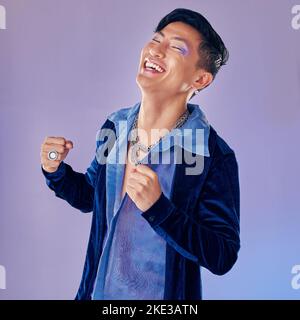 Asiatische Model, Mode und Lächeln mit glücklichem Lächeln in lila Studio Hintergrund mit Kleidung, Kosmetik und Make-up für Retro-Stil. Gesicht Schönheit eines Mannes Stockfoto