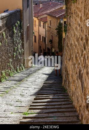 Massa Marittima, Italien - 11. September 2022: Steile und schmale Straße in der Altstadt von Massa Marittima, Italien Stockfoto