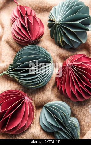 Handgemachte Öko Papierkugel, Nahaufnahme. Weihnachtsdekoration auf braunem Strickhintergrund. Stockfoto