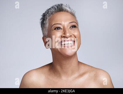 Kosmetik, ältere Frau und Denken mit Hautpflege für Wellness, Gesundheit und natürliche Schönheit mit grauem Studiohintergrund. Selbstbewusst, reife Dame und Stockfoto