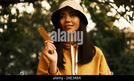 Das Mädchen hält eine trockene dünne Scheibe Brot in der Hand Stockfoto