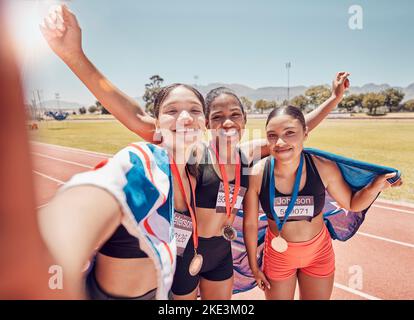 Selfie, Medaille und Freunde mit britischer Flagge nach Laufen, Fitness und Sport in einem Stadion. Zusammenarbeit, Gewinner und Frauen Athletenkreis mit einem Stockfoto