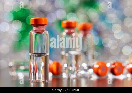 Nahaufnahme der Medizin zur Injektion in Glasfläschchen auf einem farbenfrohen Hintergrund Stockfoto