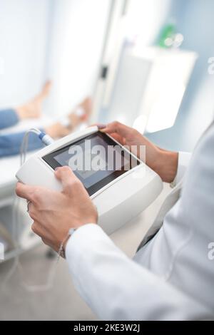 Der Ernährungswissenschaftler hält eine plicometrische Messmaschine Stockfoto